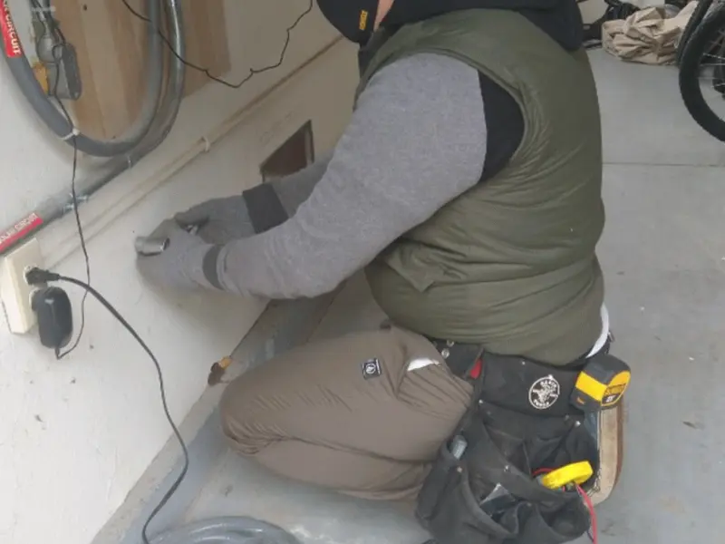 Electrician performing outlet wiring in a Highland Lakes garage